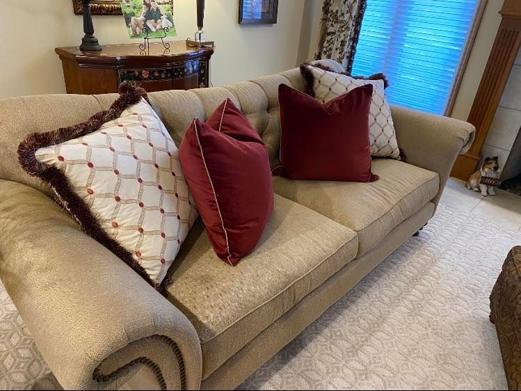A couch with red and white pillows on it in a living room