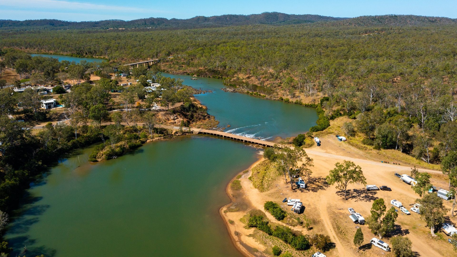 A Beach With Rocks and a Body of Water in the Background — Werry Building Services in Tannum Sands, QLD