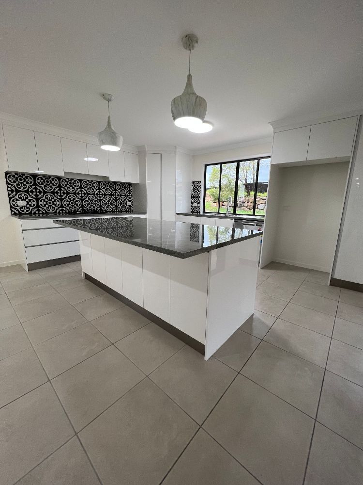 A Long Hallway With Tile Floors and White Walls in a House — Werry Building Services in Boyne Island, QLD