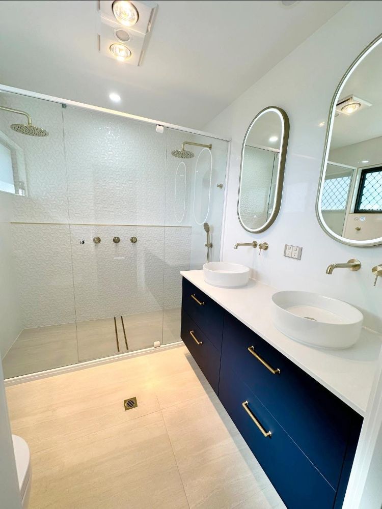 A Large White House With a Gray Garage Door — Werry Building Services in Boyne Island, QLD