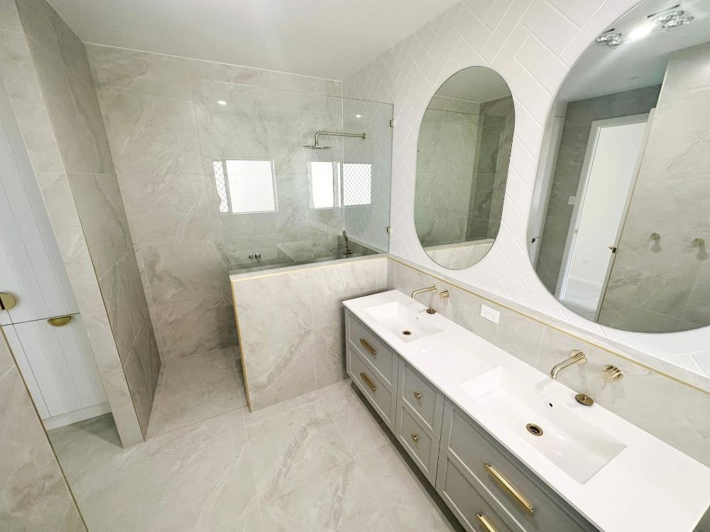 A Bathroom With a Bathtub, Sink, Mirror and Walk in Shower — Werry Building Services in Boyne Island, QLD