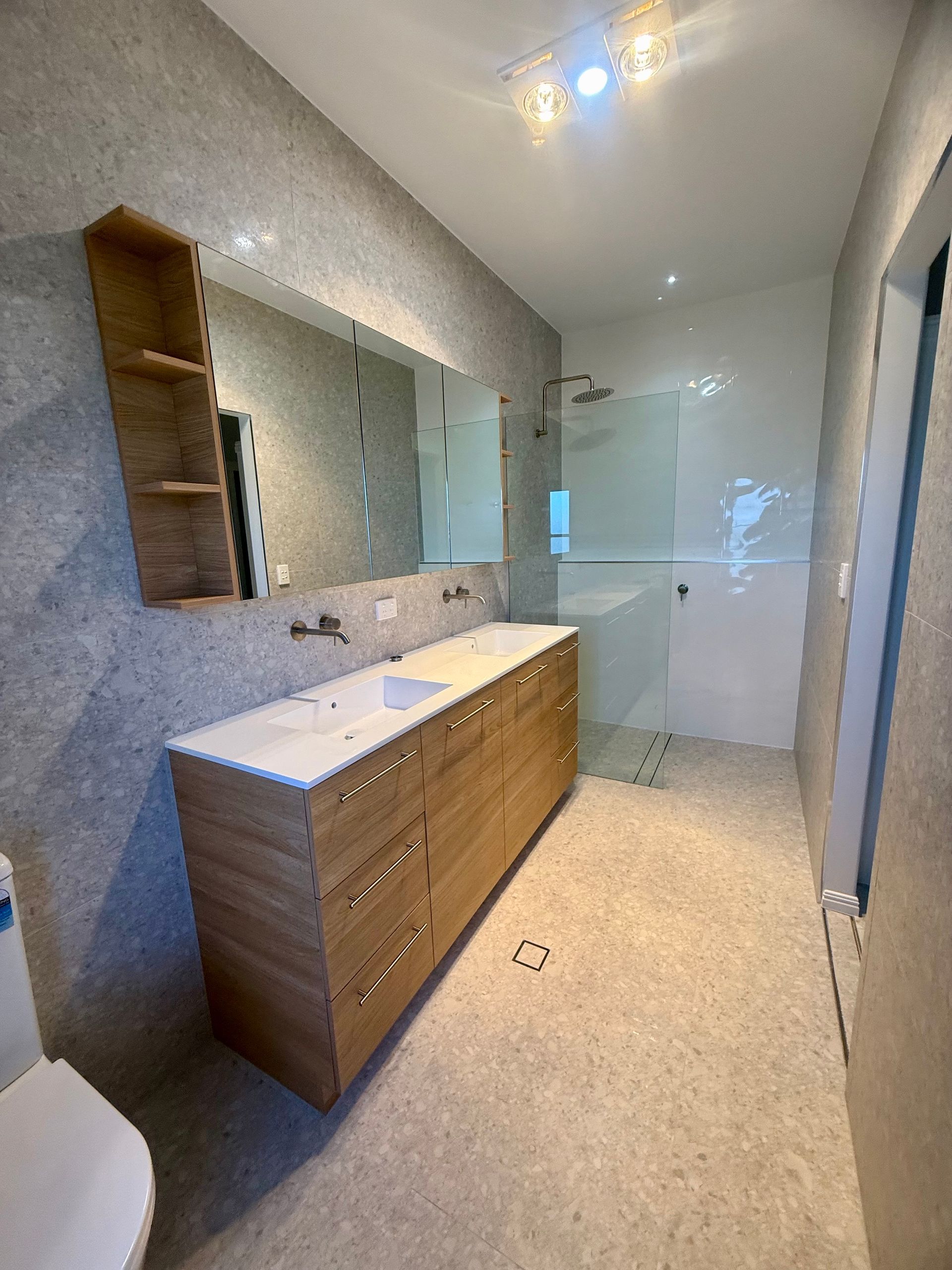 A Large Empty Room With a Kitchen and a Ceiling Fan — Werry Building Services in Boyne Island, QLD
