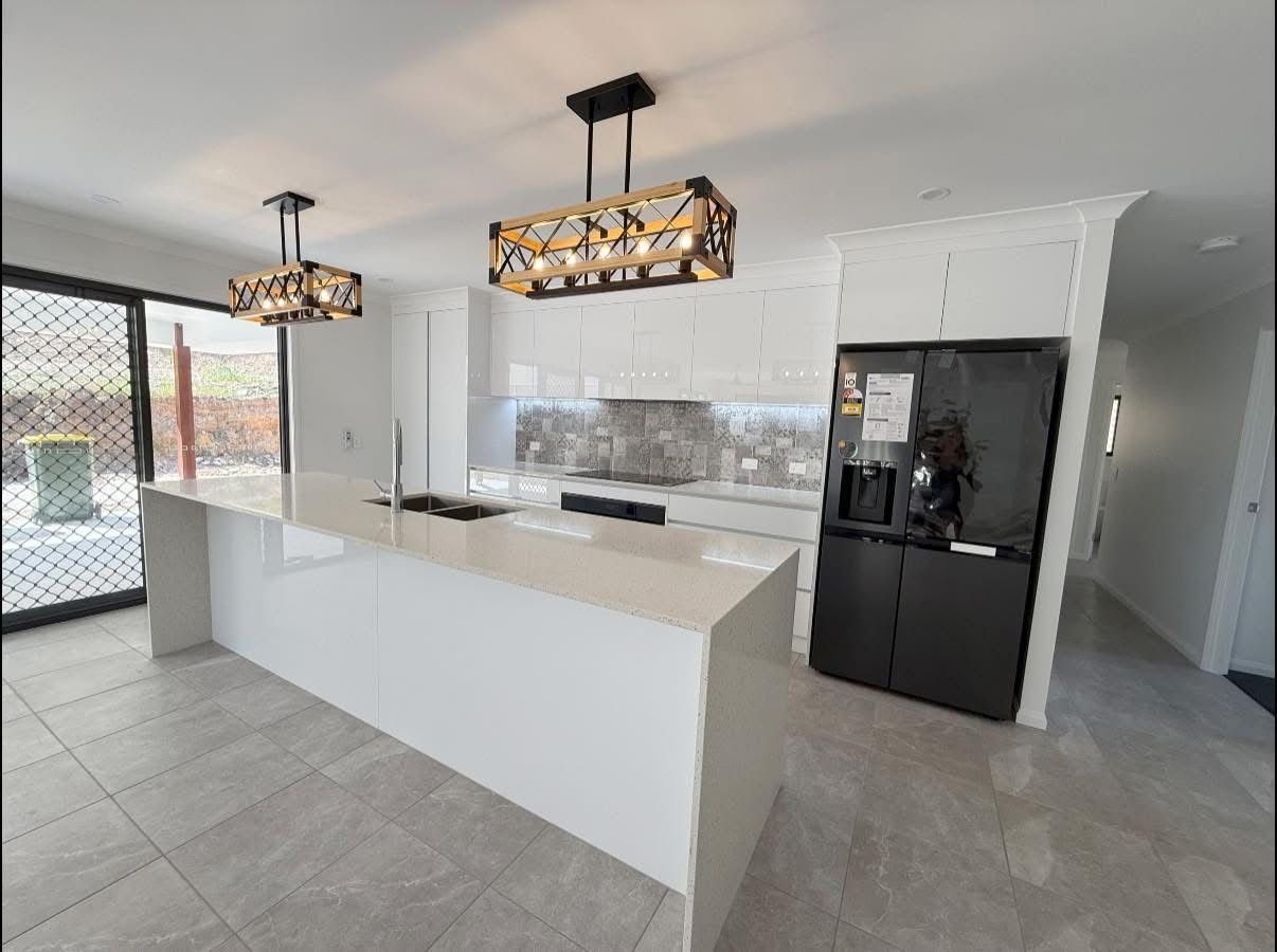 A White House With a Wooden Deck and Stairs — Werry Building Services in Tannum Sands, QLD