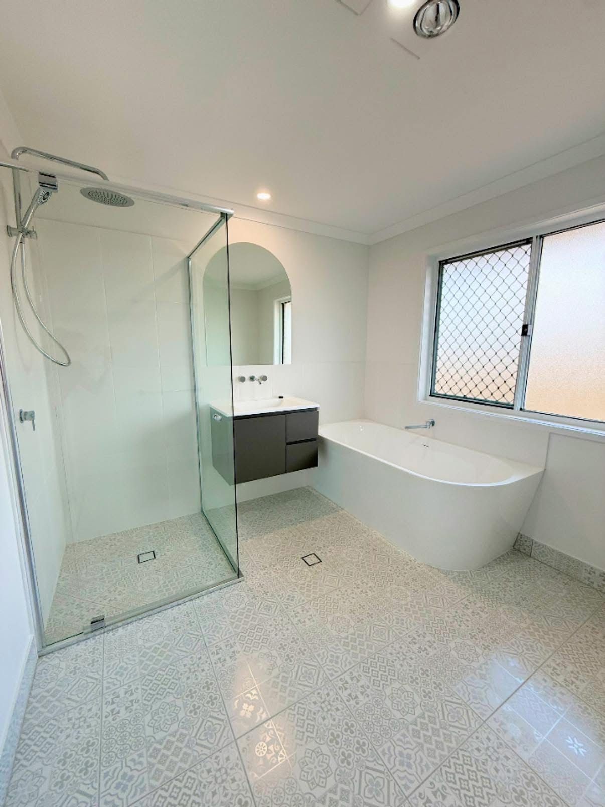 A Large Empty Room With a Kitchen and a Ceiling Fan — Werry Building Services in Boyne Island, QLD