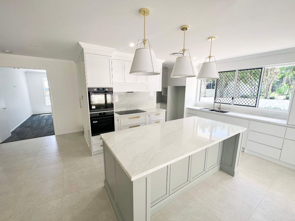 A Large Empty Room With a Kitchen and a Lot of Windows — Werry Building Services in Boyne Island, QLD