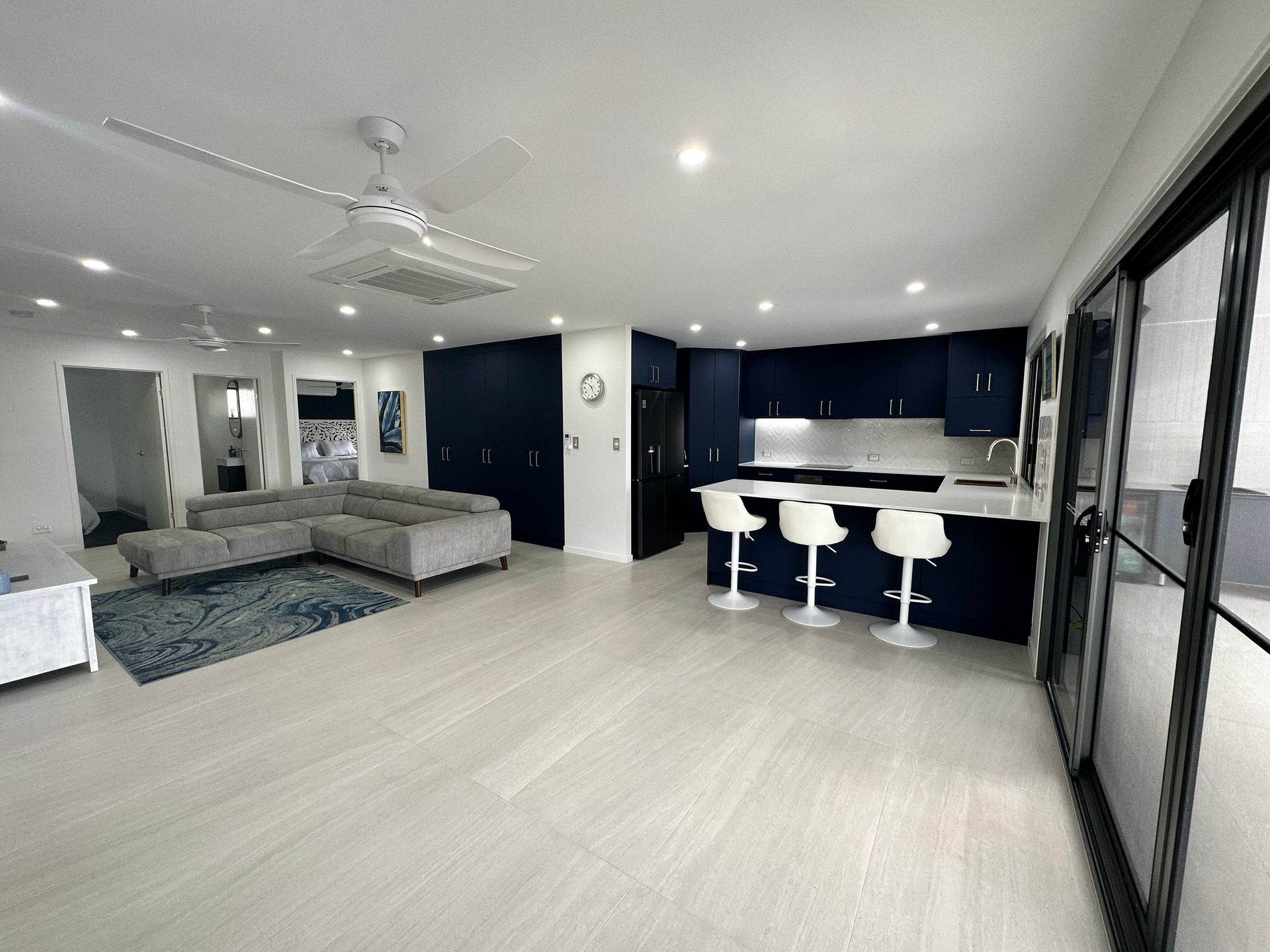 A Kitchen With Blue Cabinets and White Counter Tops — Werry Building Services in Boyne Island, QLD