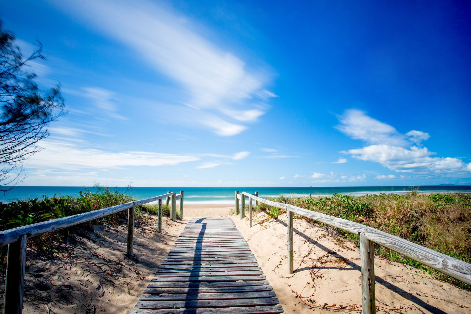 A Beach With Rocks and a Body of Water in the Background — Werry Building Services in Tannum Sands, QLD