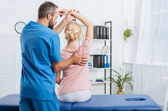 Physiotherapist Stretching Patient's Arm — Moulton, AL — Plaxco Chiropractic Clinic
