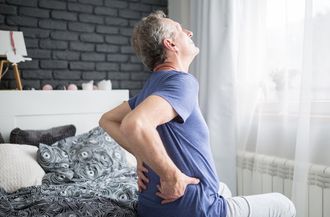 Senior Man With Lower Back Pain Siting On Bed — Moulton, AL — Plaxco Chiropractic Clinic