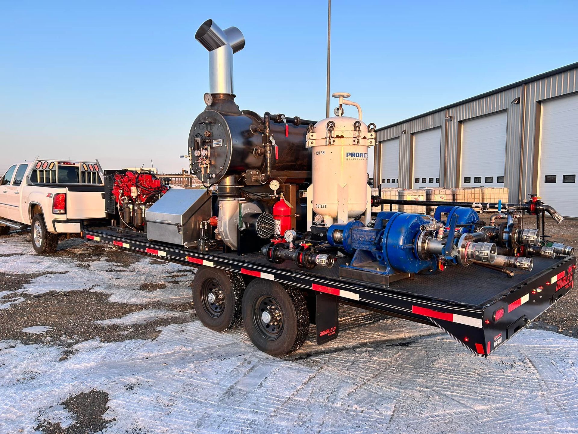 A truck is parked next to a trailer with a lot of equipment on it.