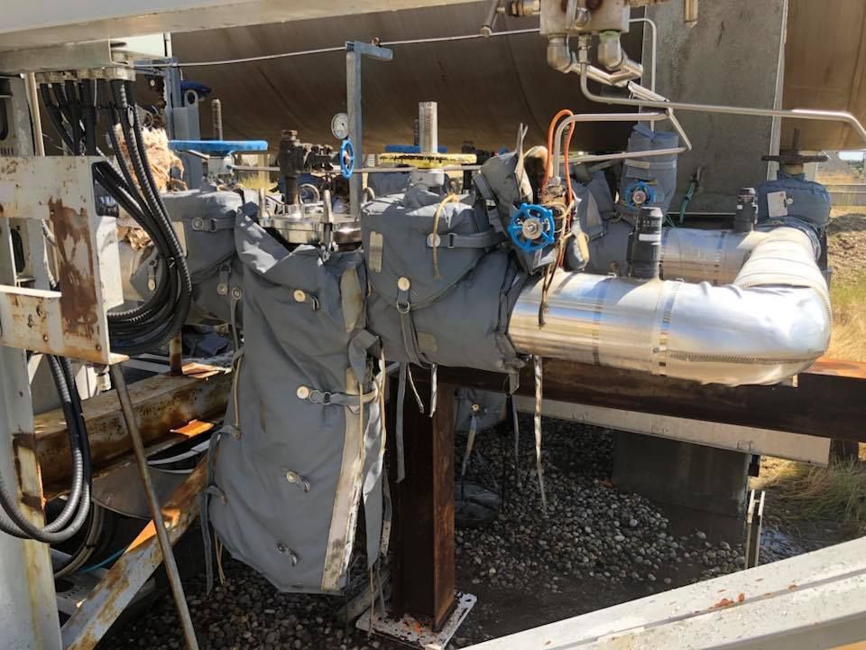 A bunch of pipes are connected to a machine in a factory.