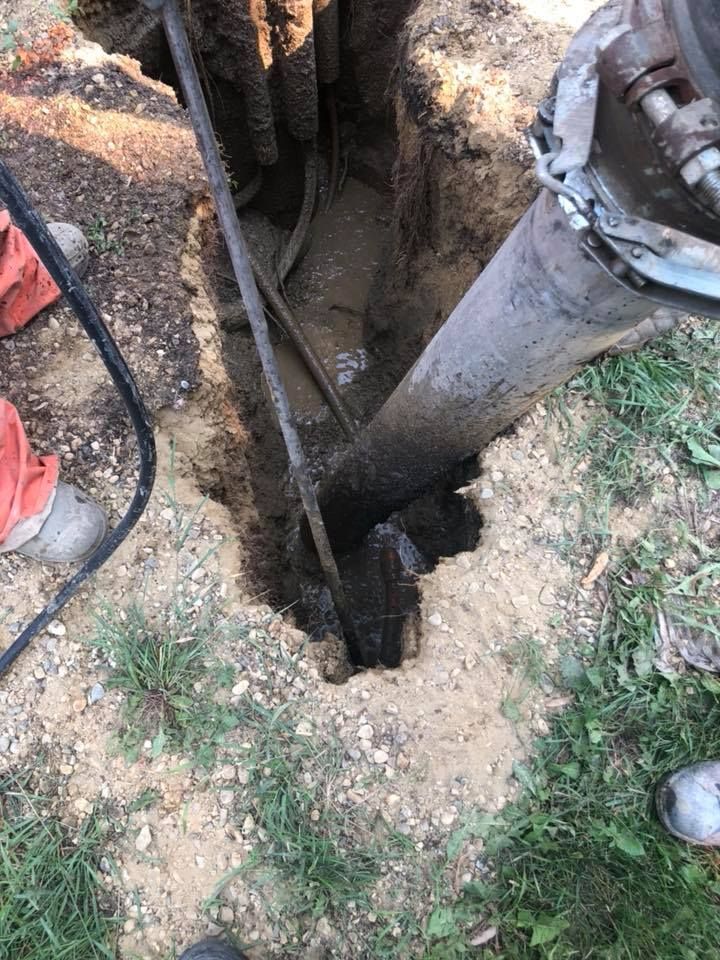 A person is using a machine to dig a hole in the ground.