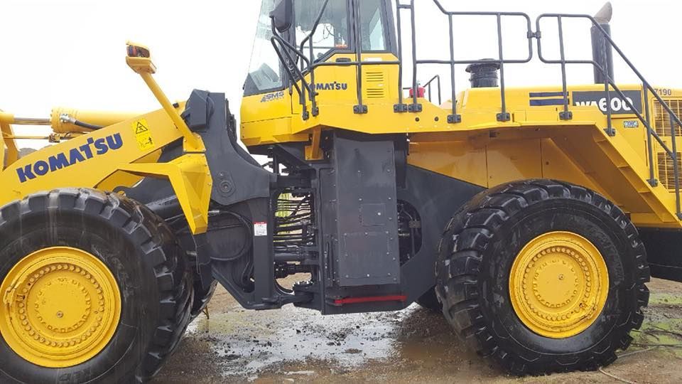 A yellow komatsu bulldozer is parked in the dirt
