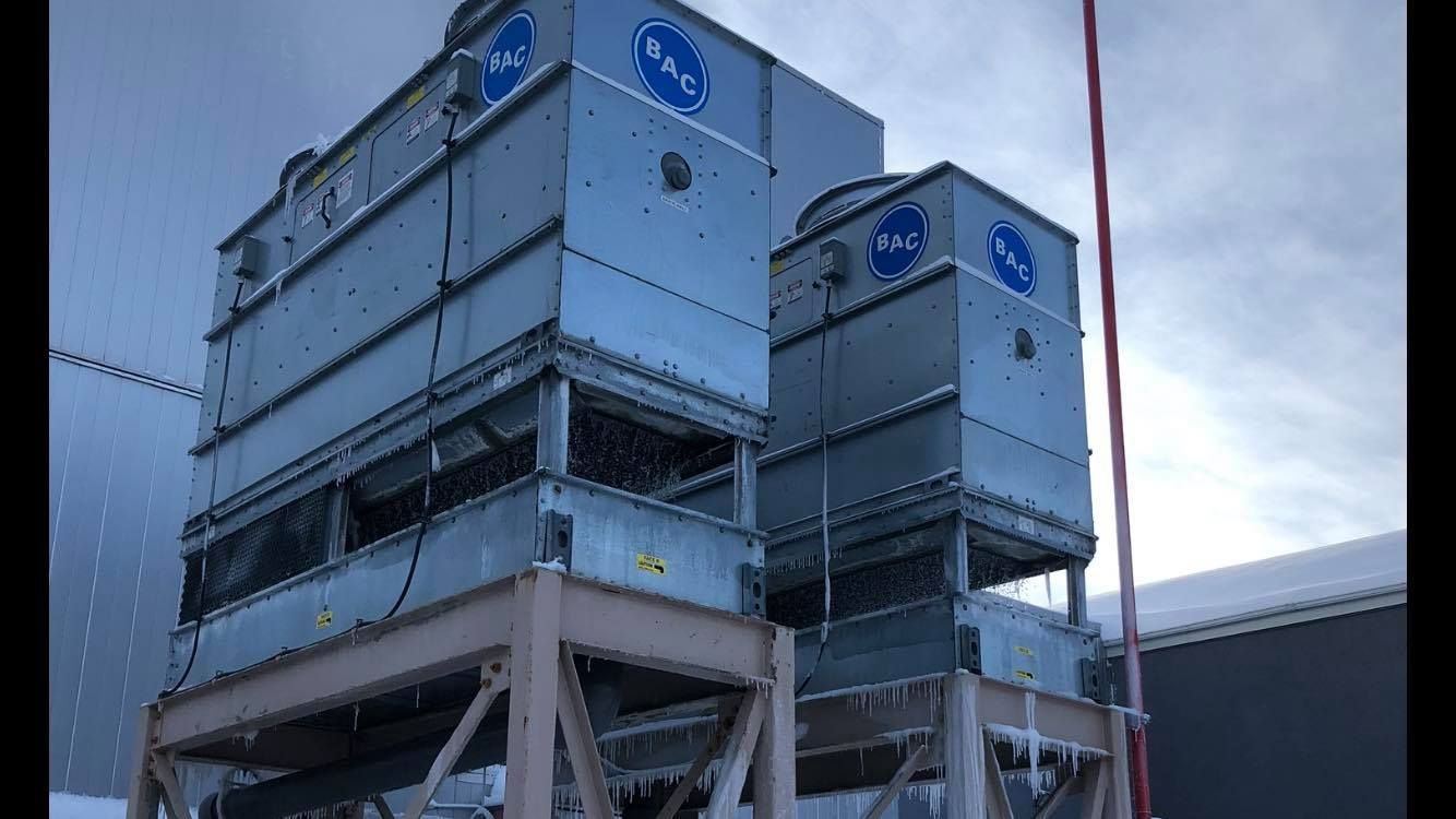 A row of cooling towers are sitting on top of each other.