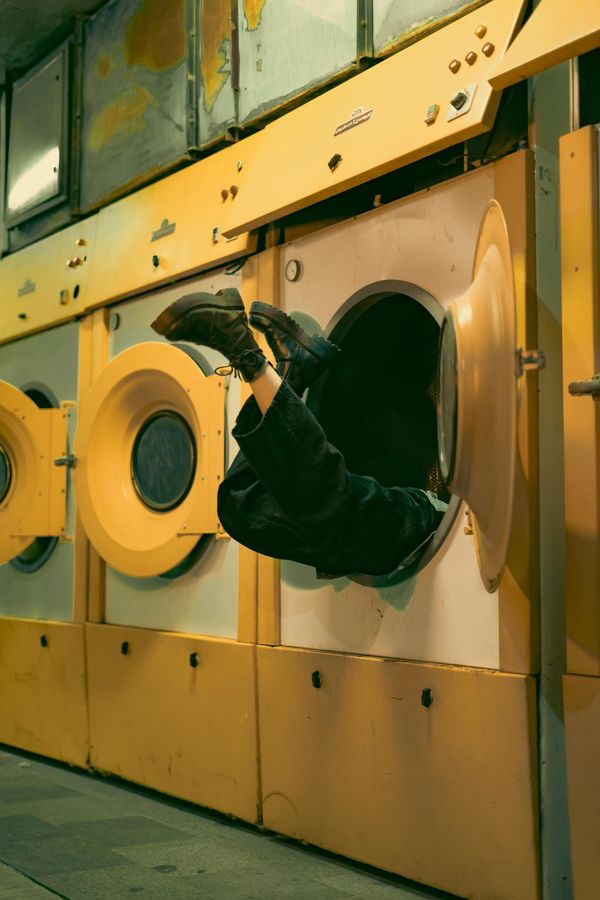 A person is falling out of a washing machine.