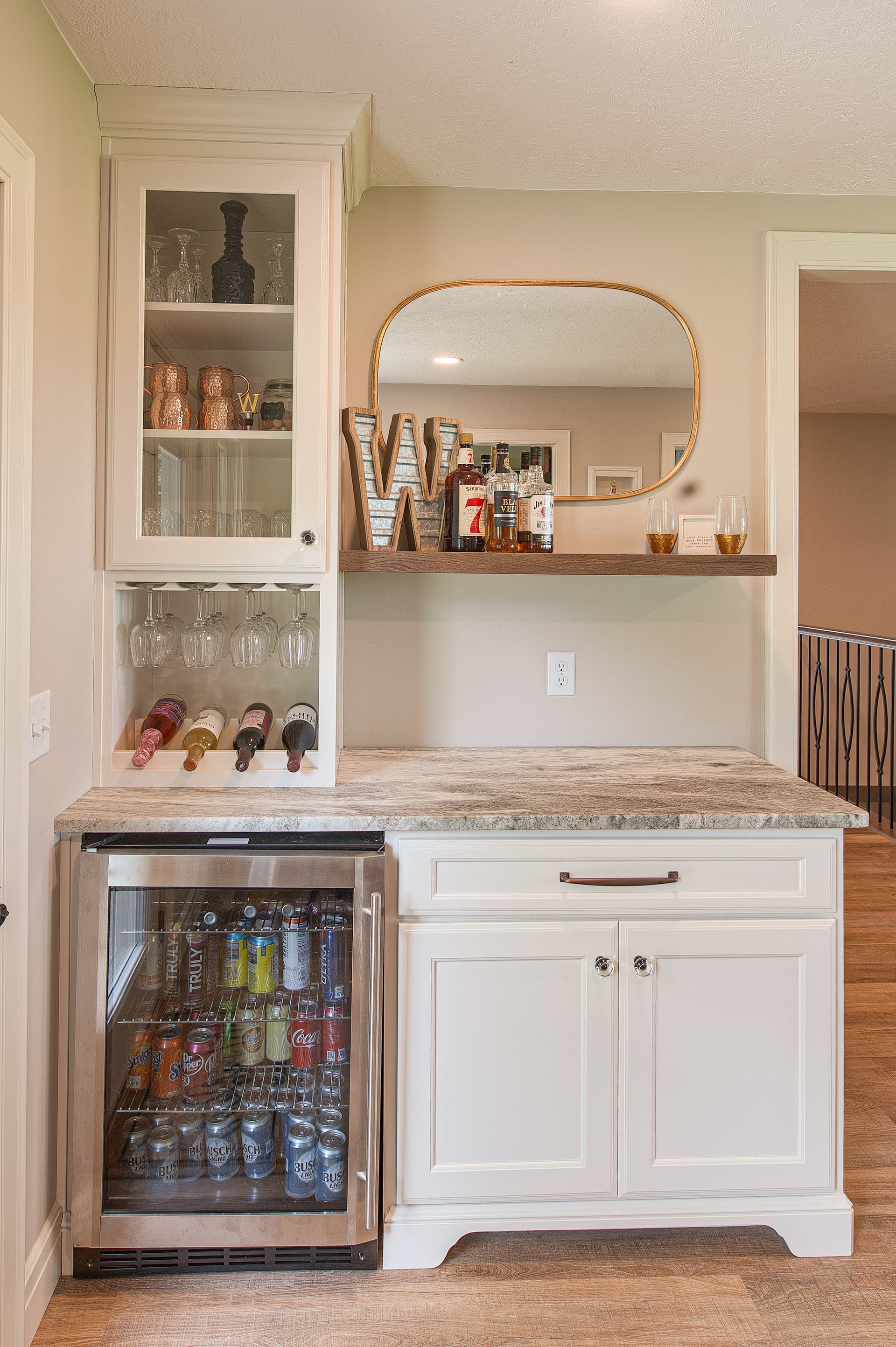A mini bar with a mini fridge for drinks to mix together.