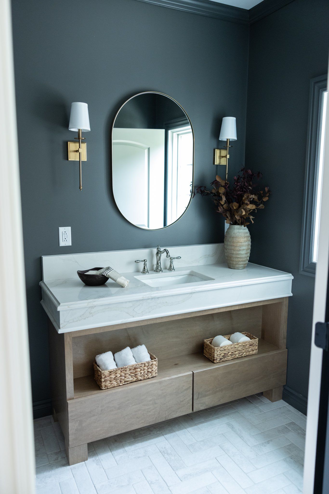Bathroom sink and a round mirror.