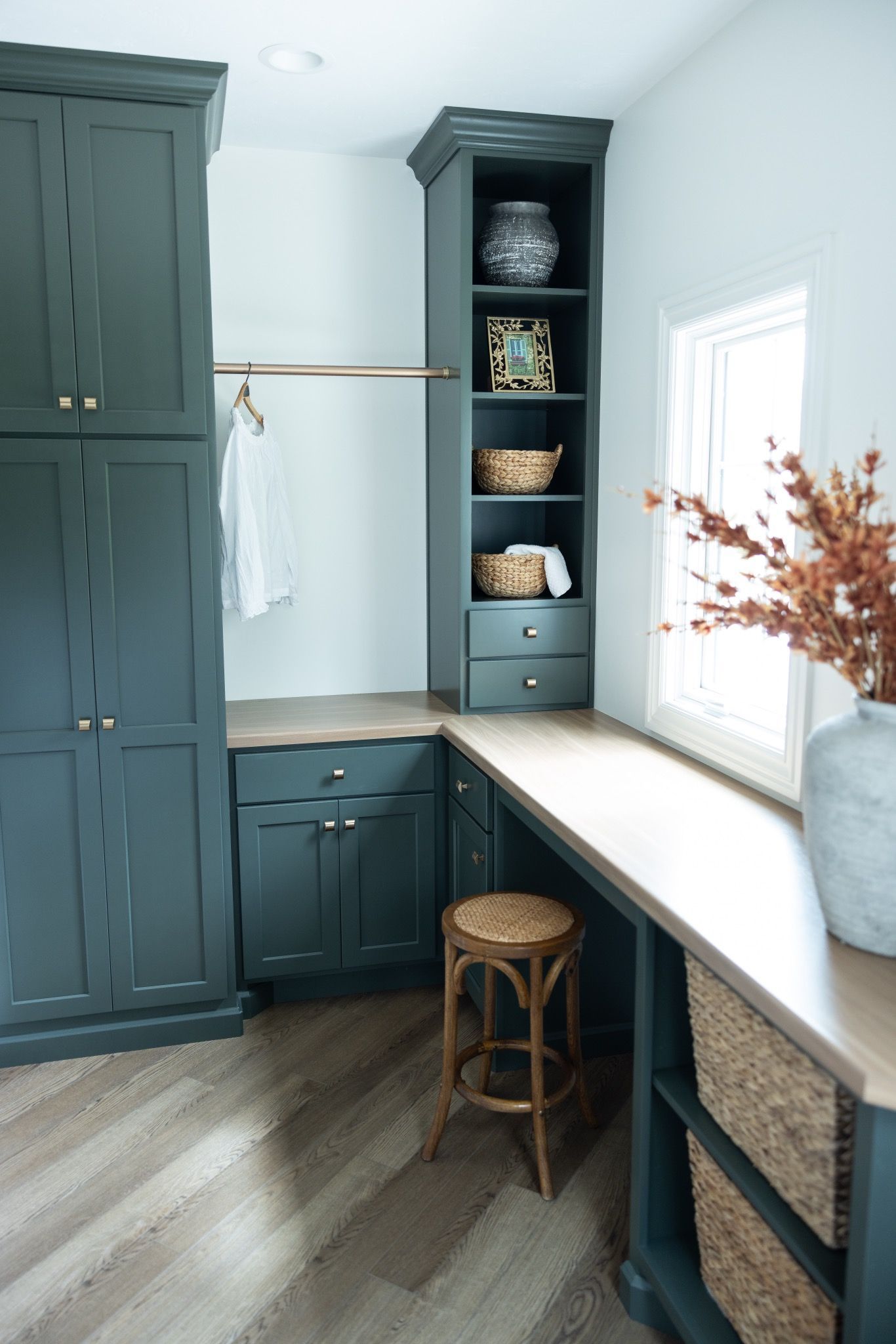 Blue laundry room with a stool pulled in under a table for folding clothes.