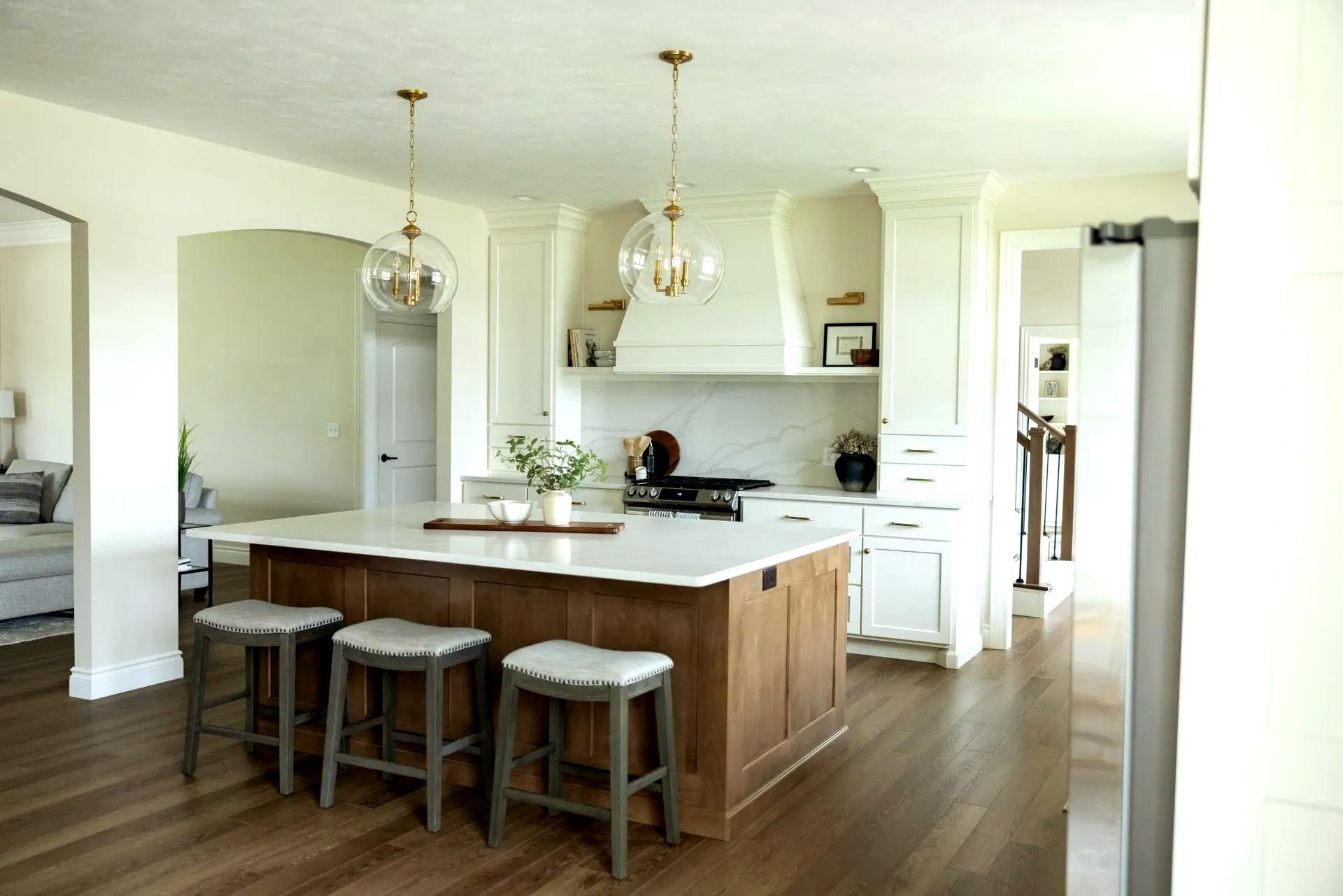 Kitchen dining area with a marble island table, hanging lights, and a oven in the corner.