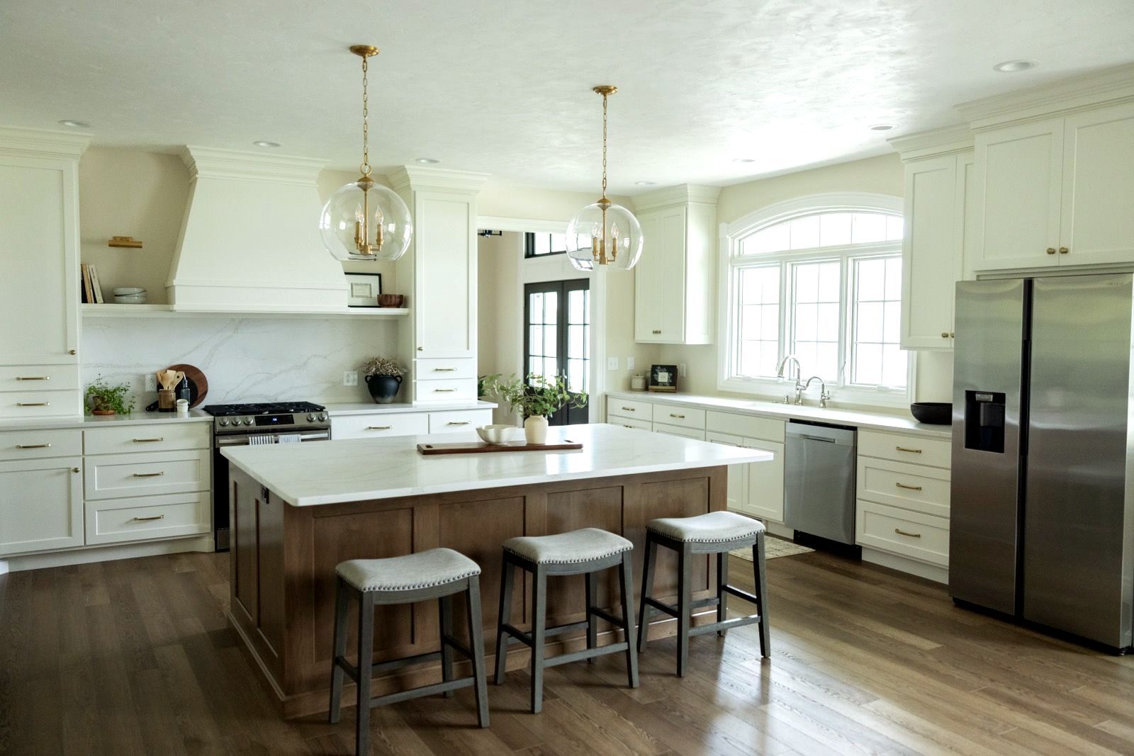 Kitchen dining area with island table, hanging lights, and sink in the corner.