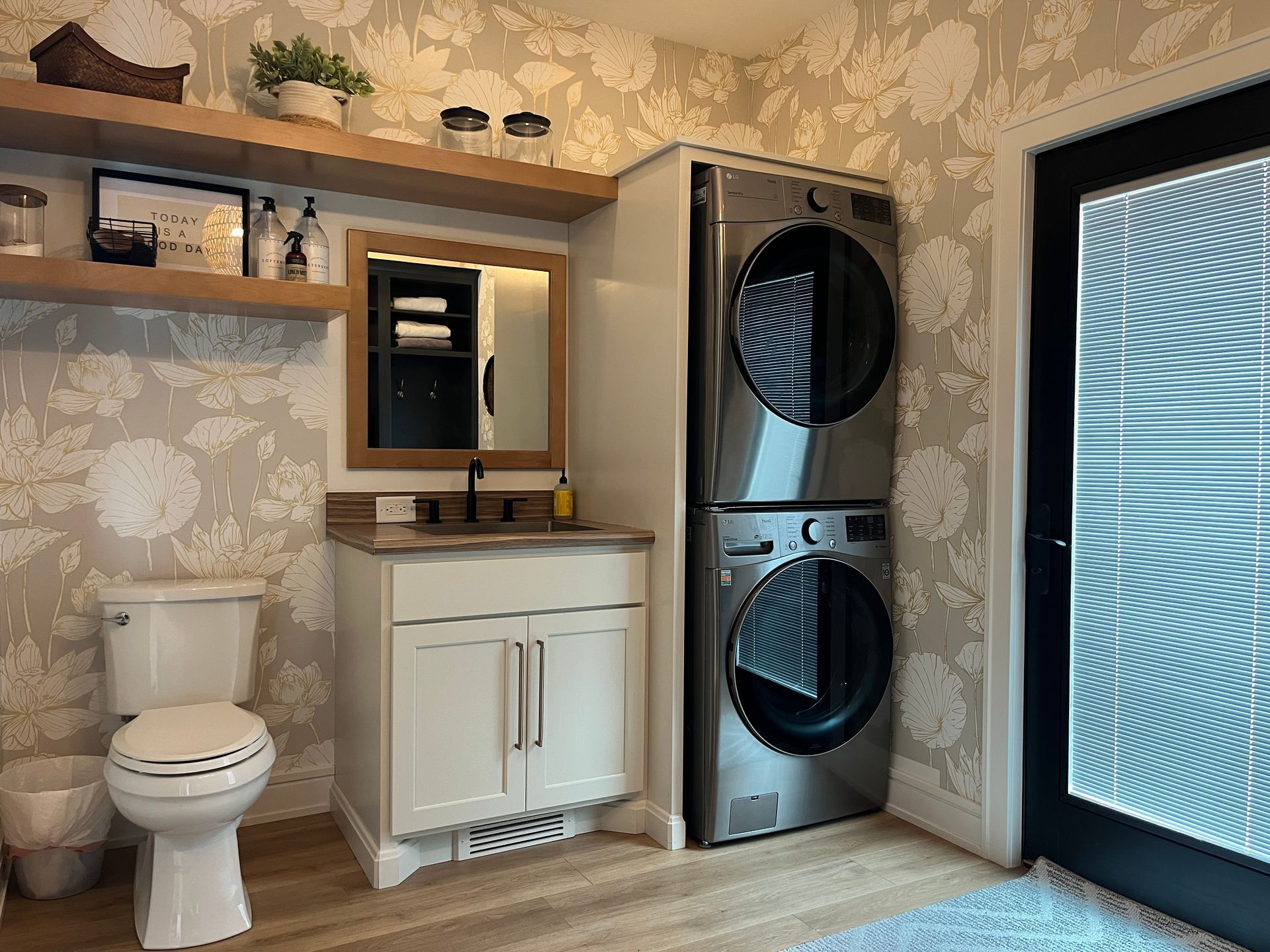 Mudroom with a toilet, sink, and washer dryer combo stacked on each other.