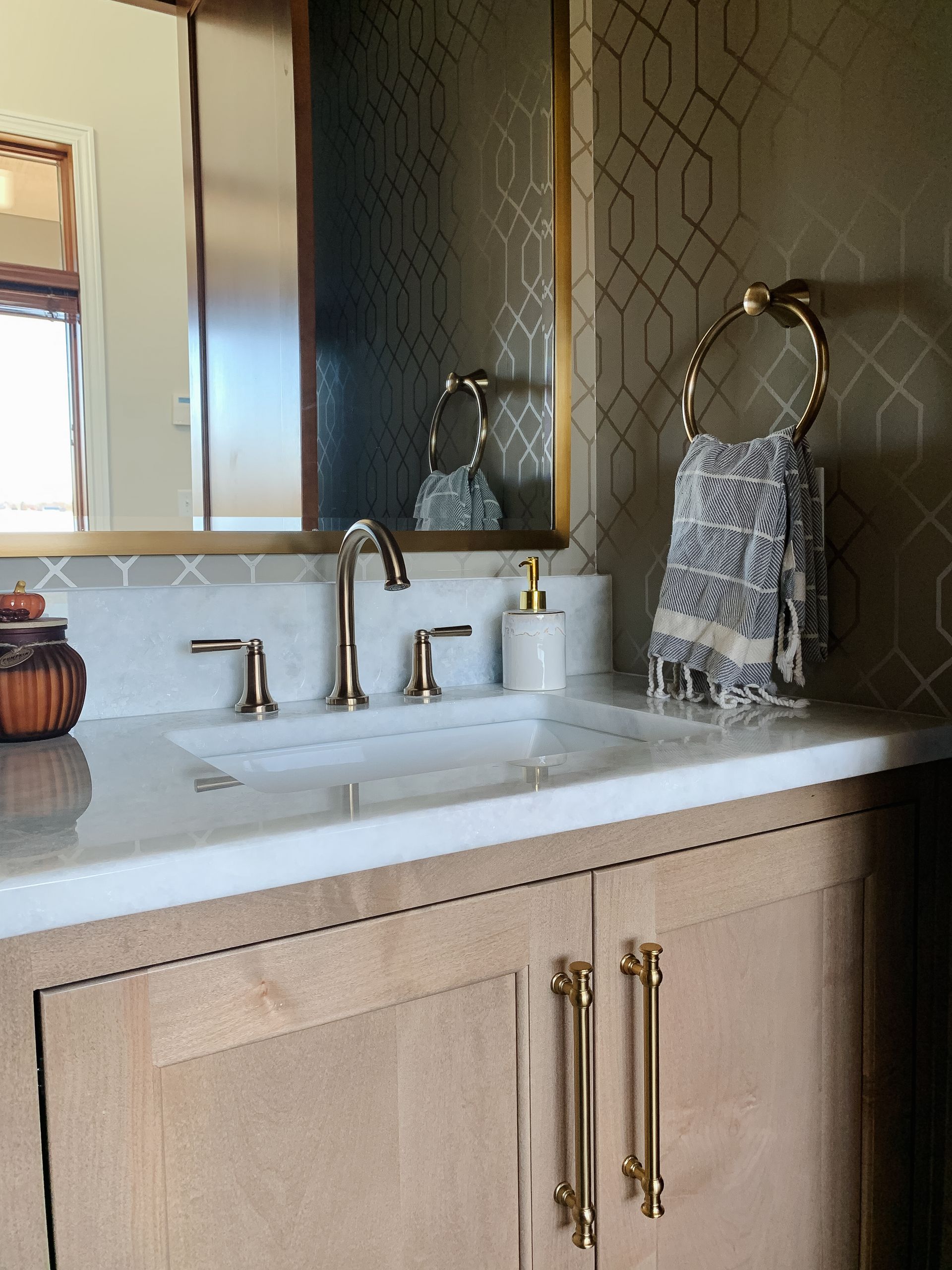 Sink and mirror with a towel and soap set out.