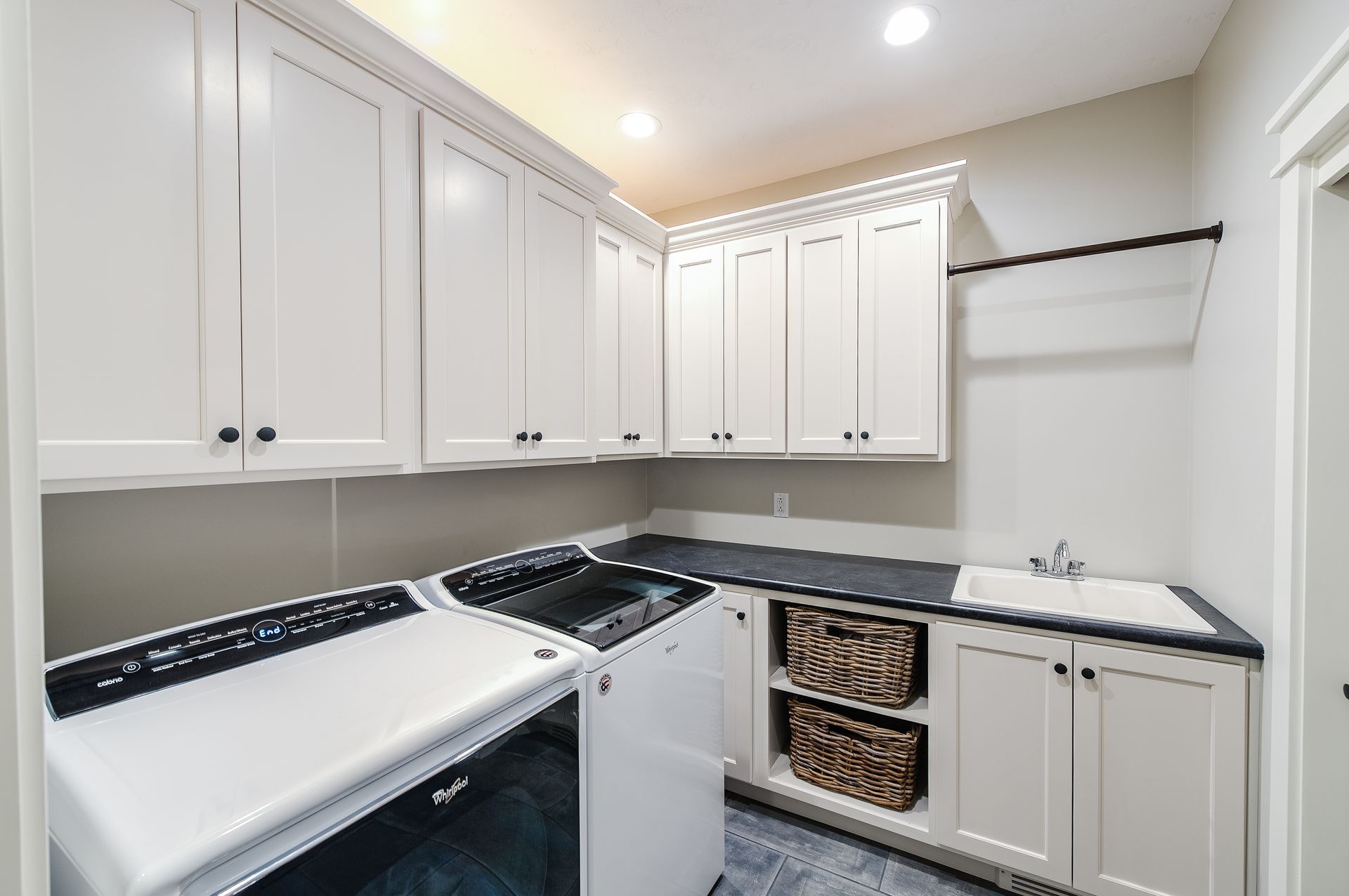 Laundry room with sink, cabinets, and washer dryer combo.