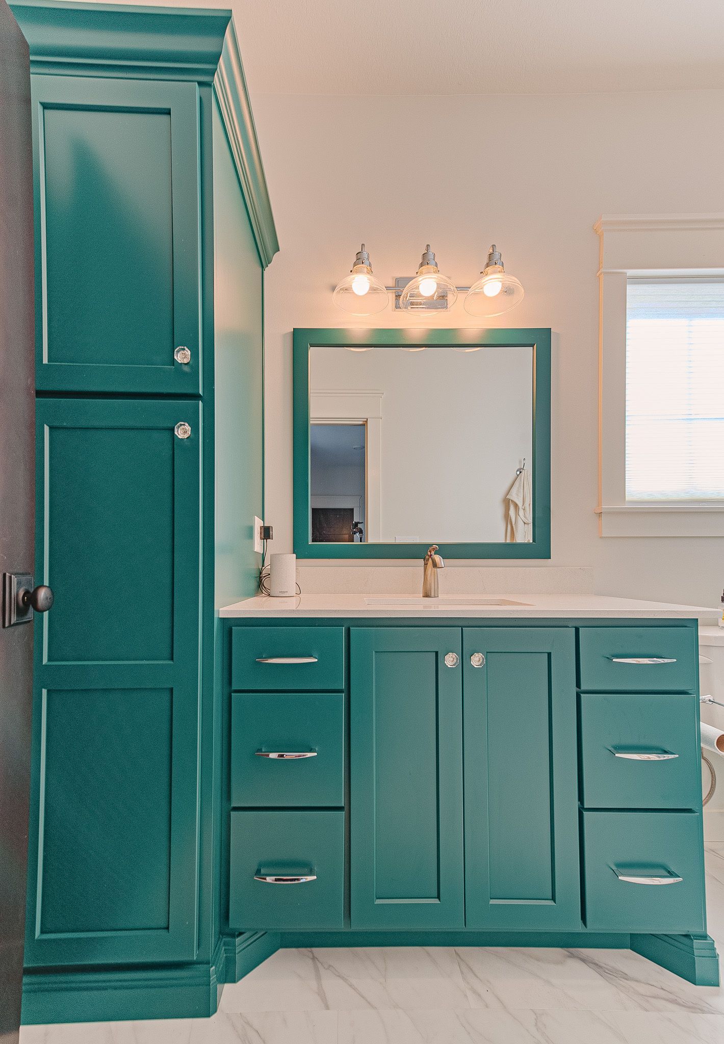 A blue sink with a blue mirror and blue cabinets to the left.