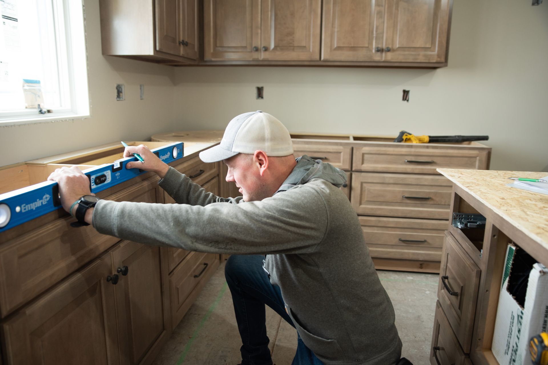 Man using a level tool in the installation of a kitchen counter.