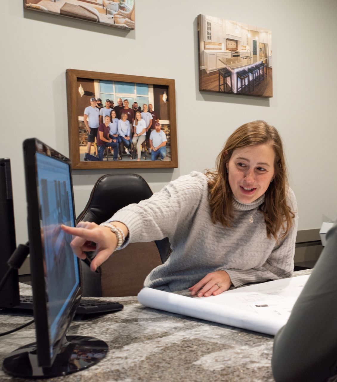 A meeting where a lady is showing a client a intentional layout they could use for the project.