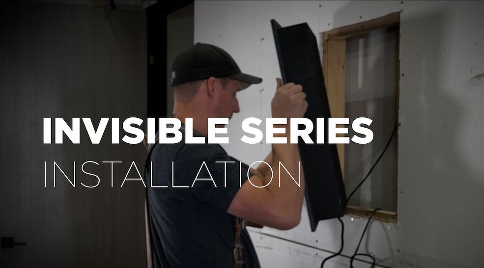 a man is installing an invisible series installation on a wall .