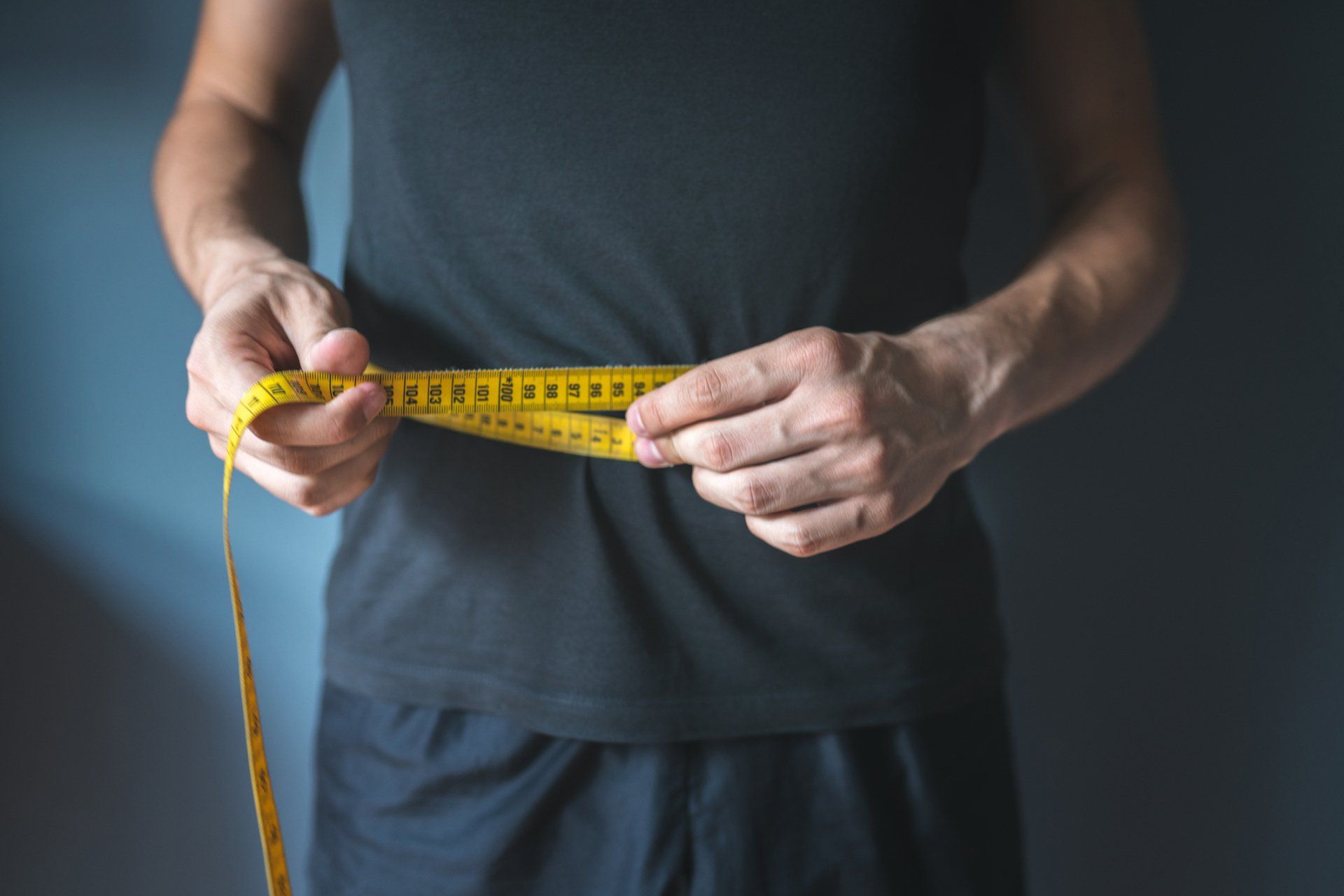 Slim Man Measuring His Waist — Hastings, NE — Adams County Chiropractic