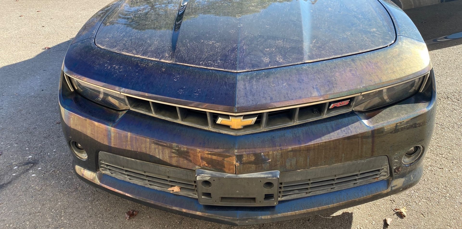 a blue chevrolet camaro is parked on the side of the road .
