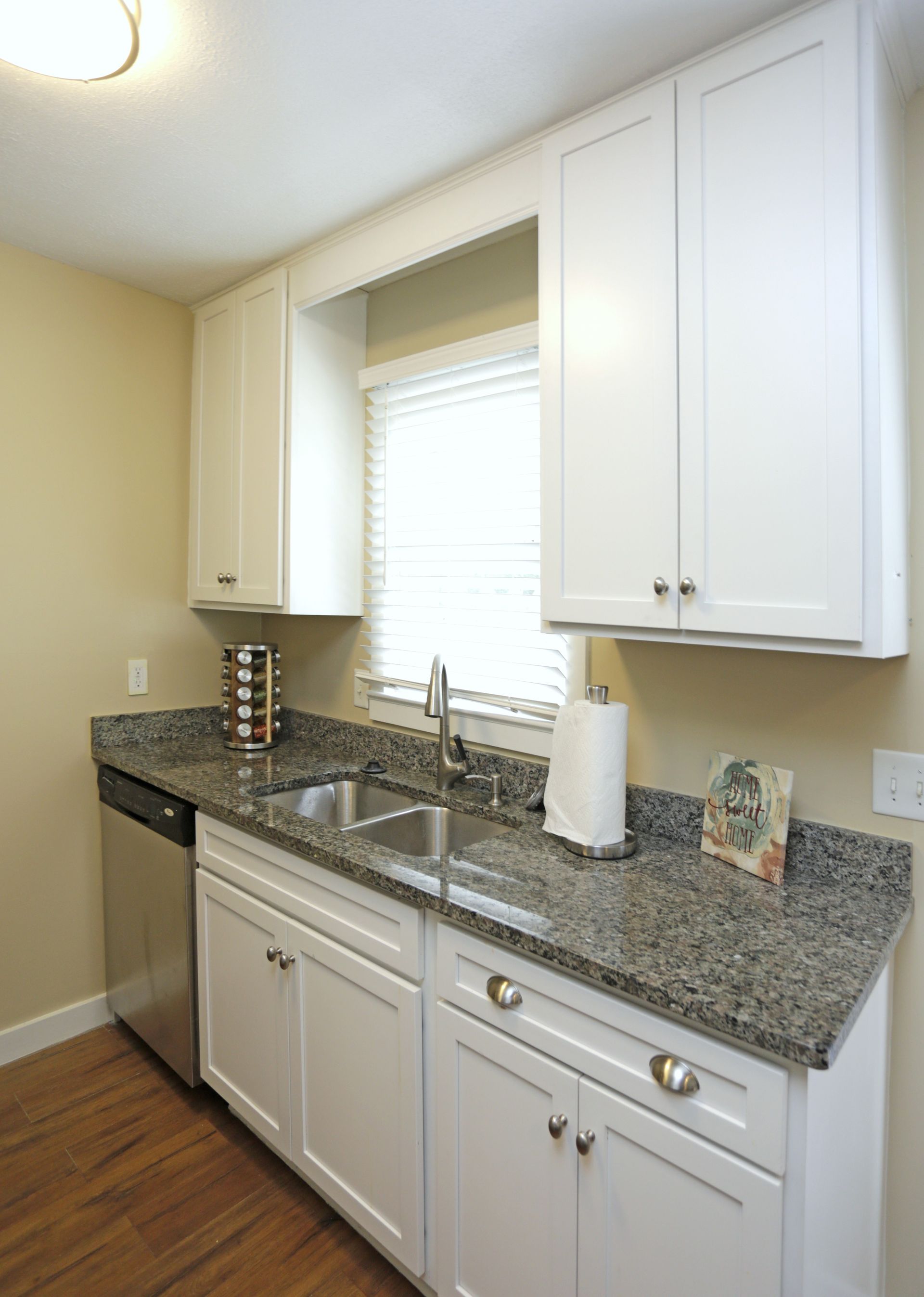 White kitchen cabinets, granite countertop, stainless steel sink and appliances.
