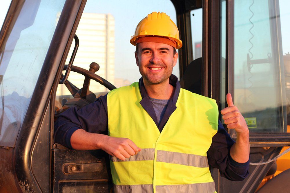 worker in safety vest and hard hat giving thumbs up