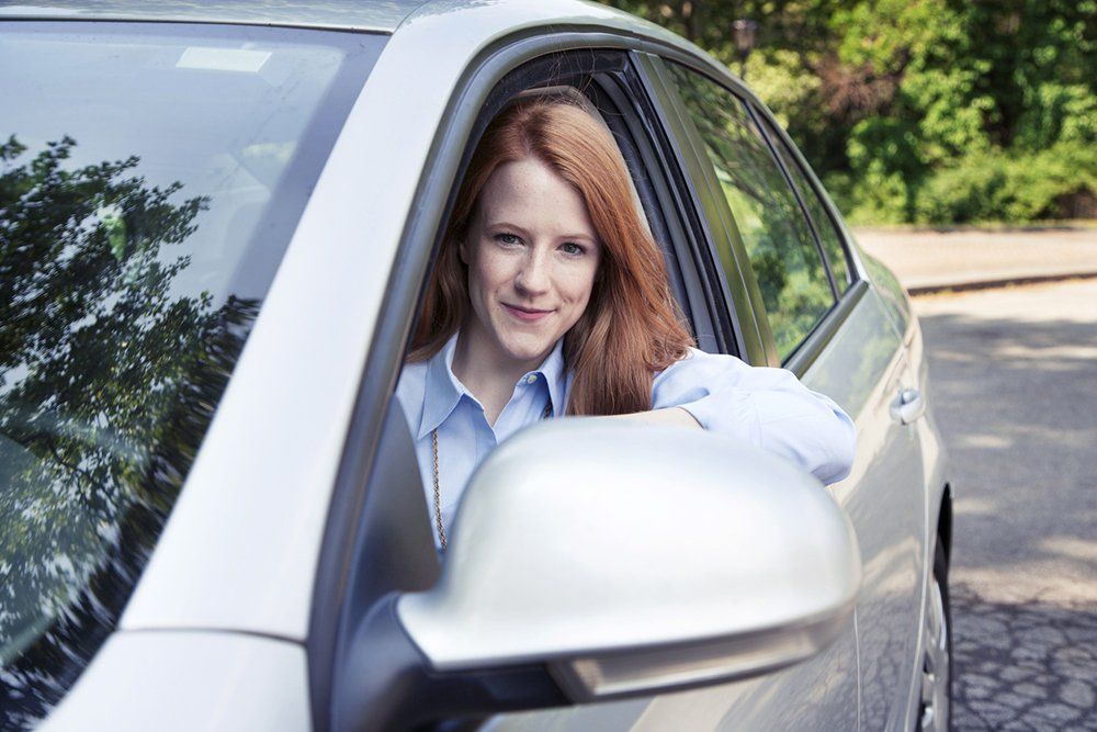 Woman Smiling While Sitting in Car