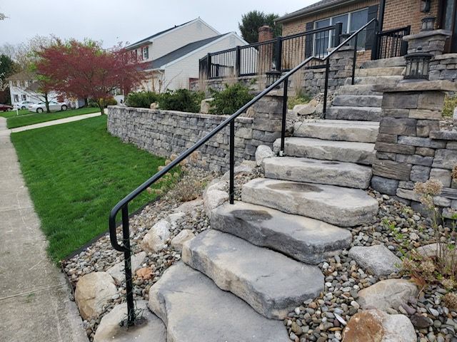 A set of stairs leading up to a house with a metal railing.