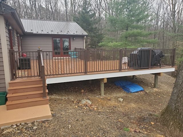 A small house with a deck and stairs in front of it.