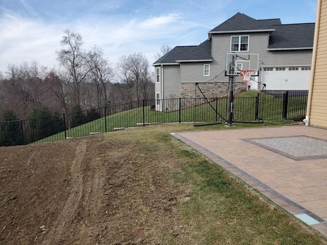 There is a basketball hoop in the backyard of a house.