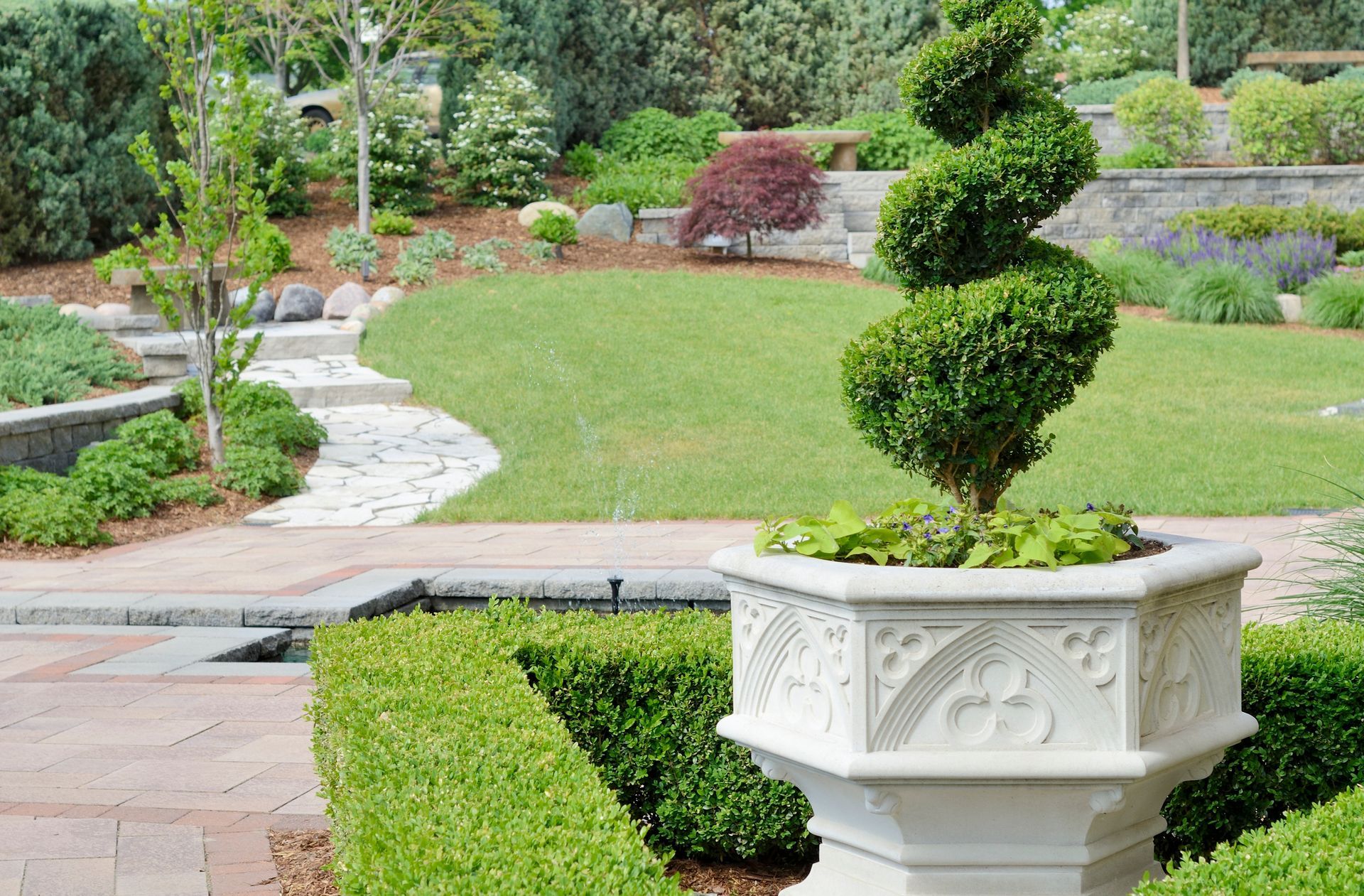 Beautifully maintained residential landscape, featuring trimmed shrubs and a pristine lawn.