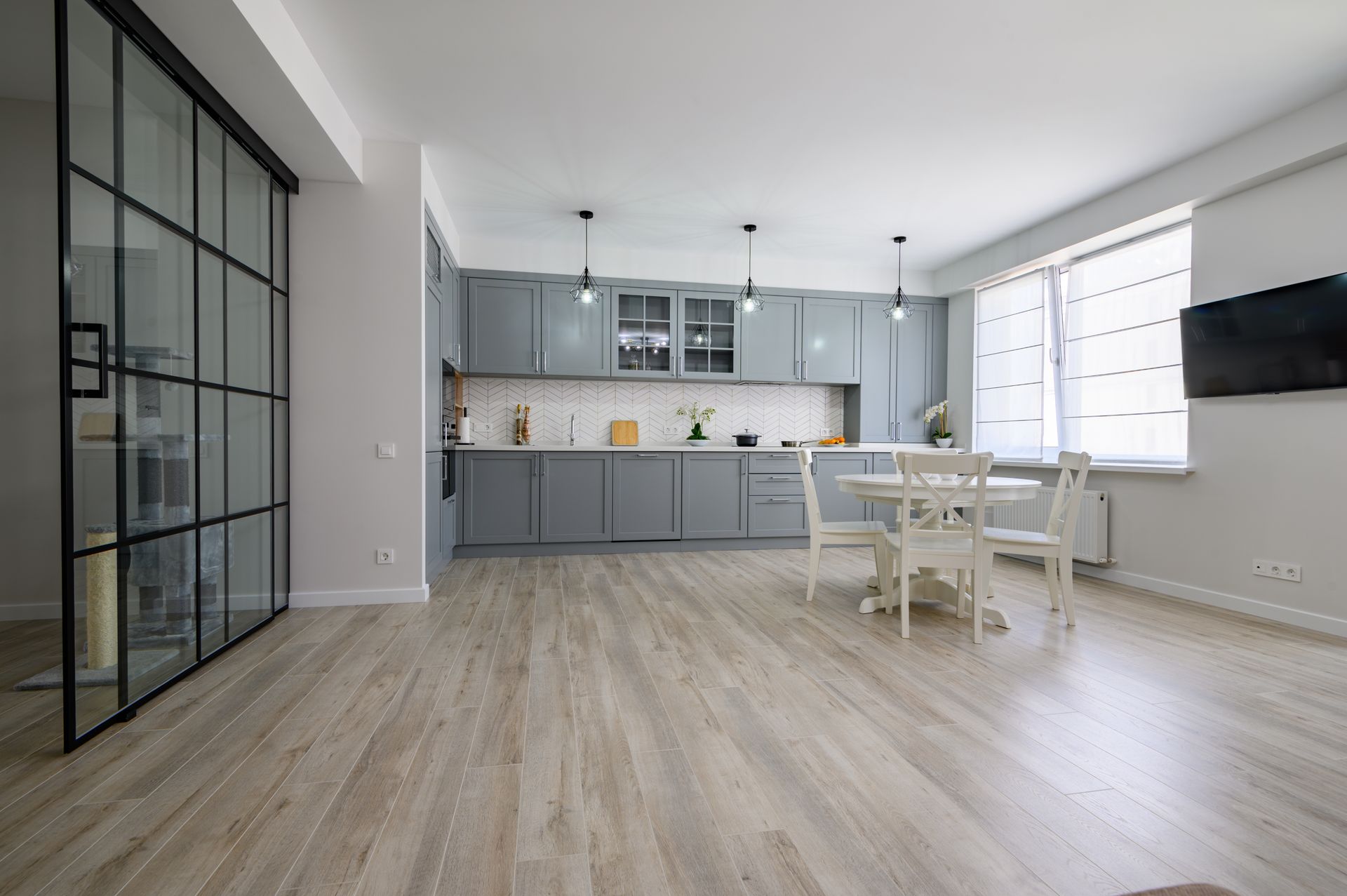 A kitchen with a dining table and chairs and a sliding glass door.