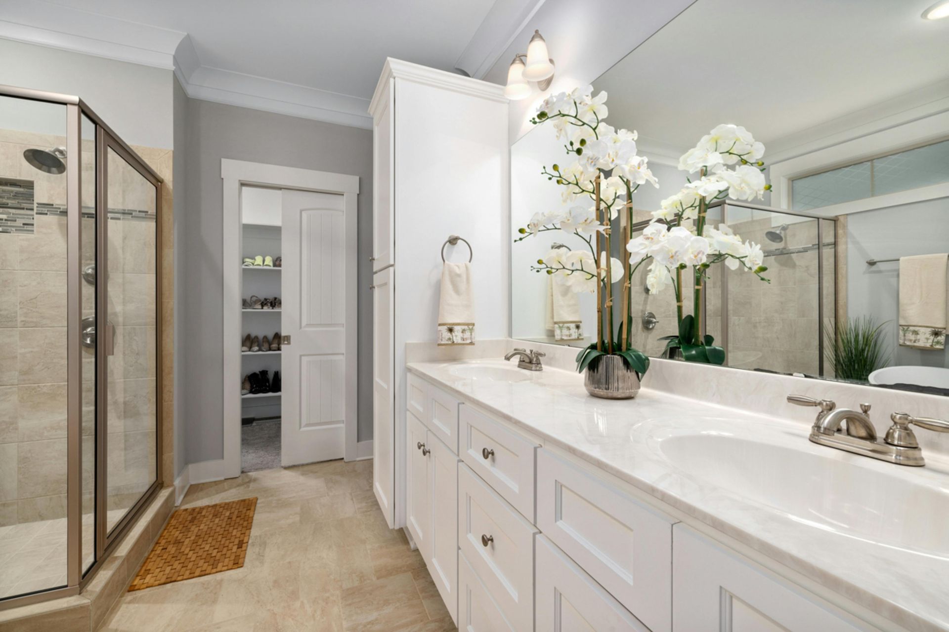 A bathroom with two sinks , a walk in shower and a large mirror.