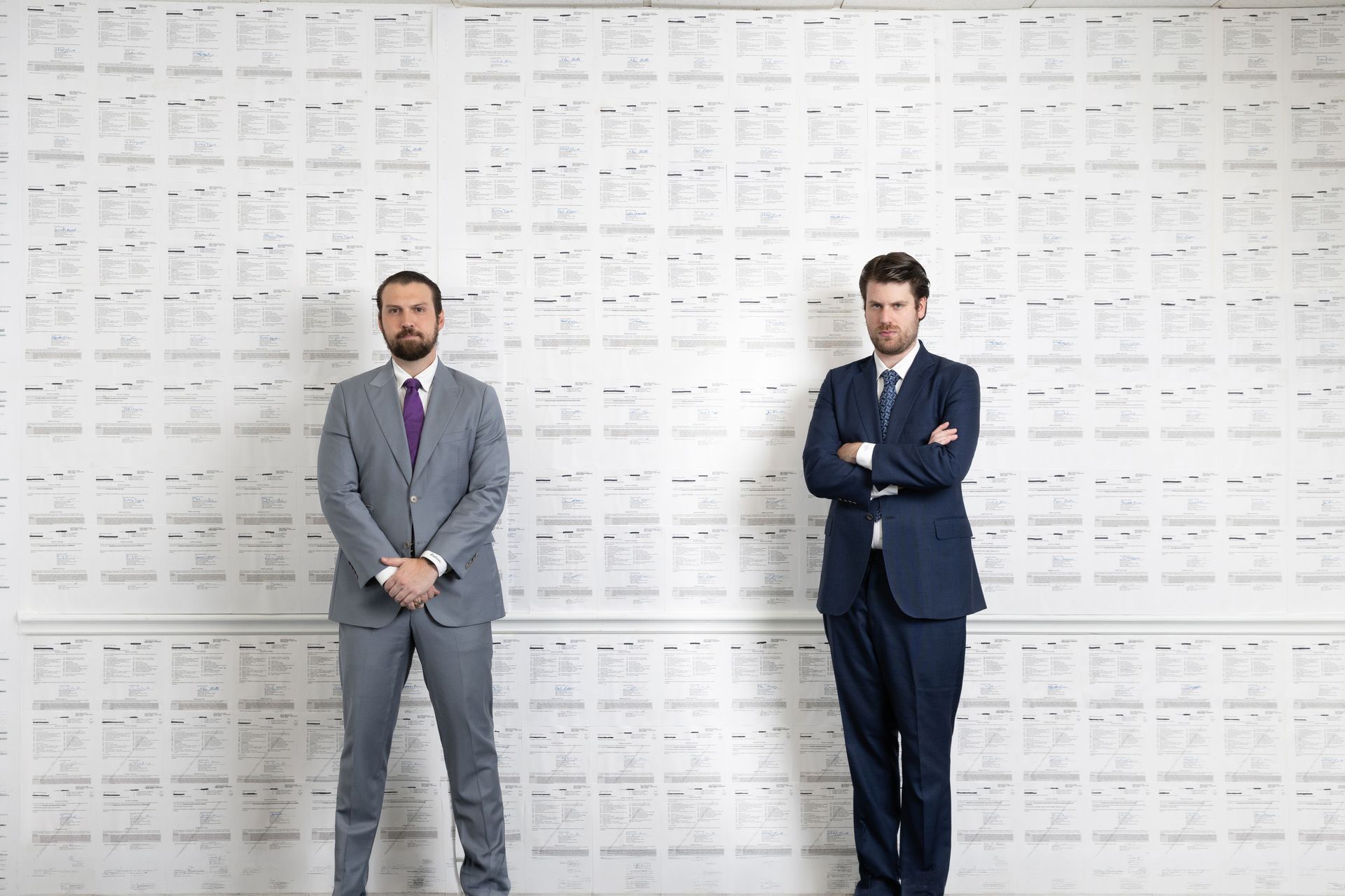 Two attorneys standing in front of a wall, with their arms crossed