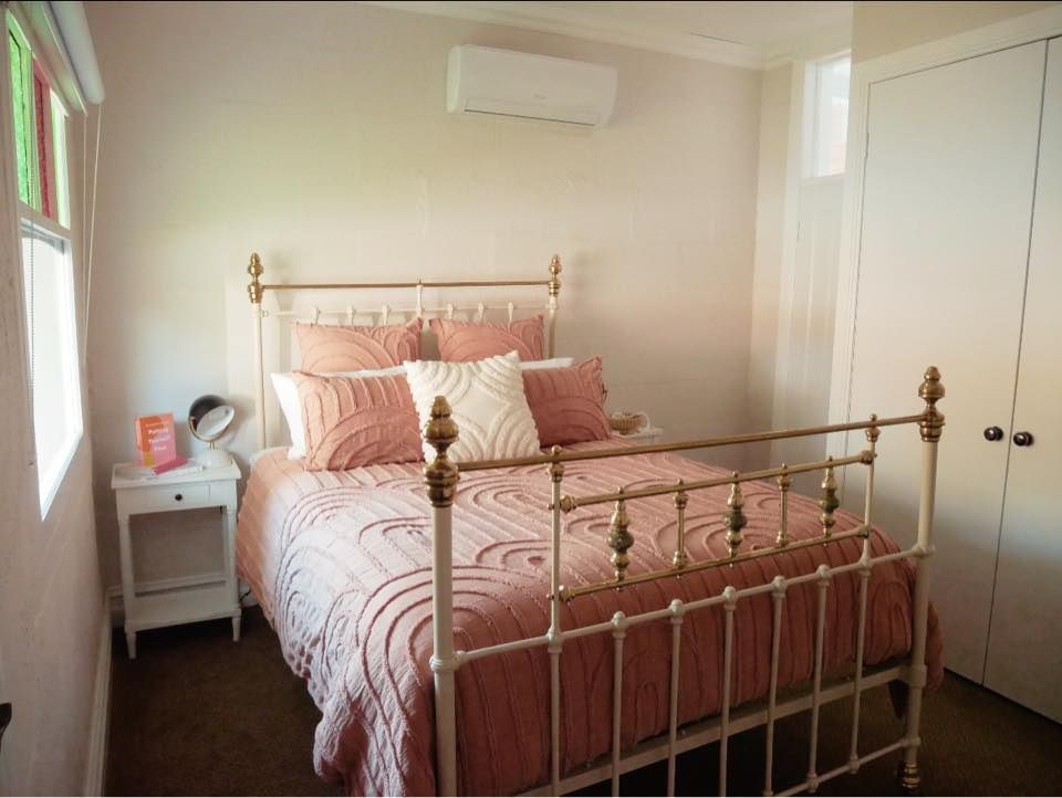 A bedroom with a bed , nightstand , and window.