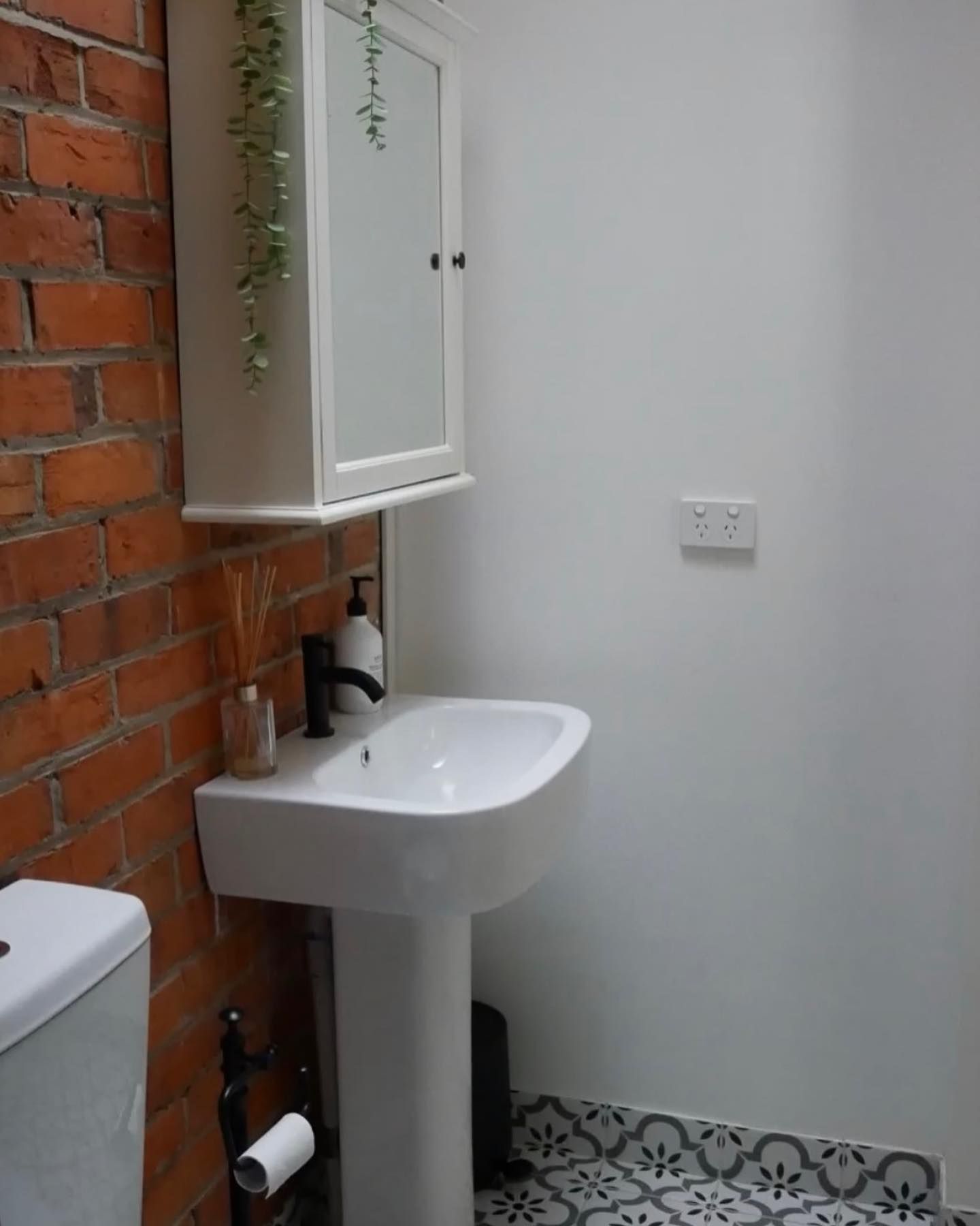 A bathroom with a sink , toilet and mirror.