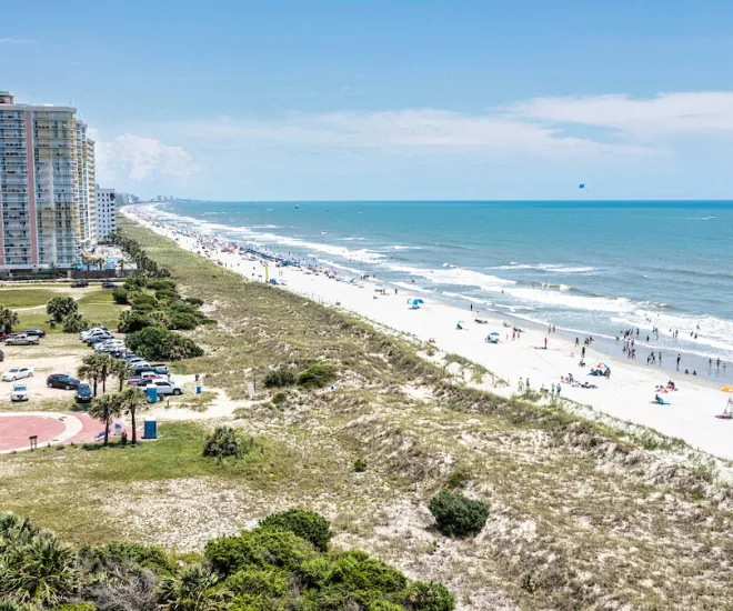 An aerial view of a beach with a lot of people on it.