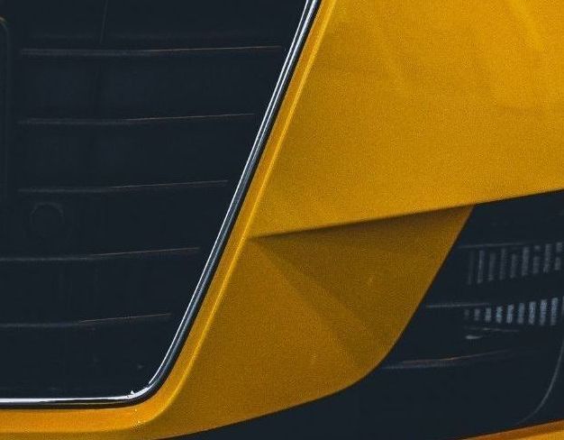 a close up of a car fender with water drops on it