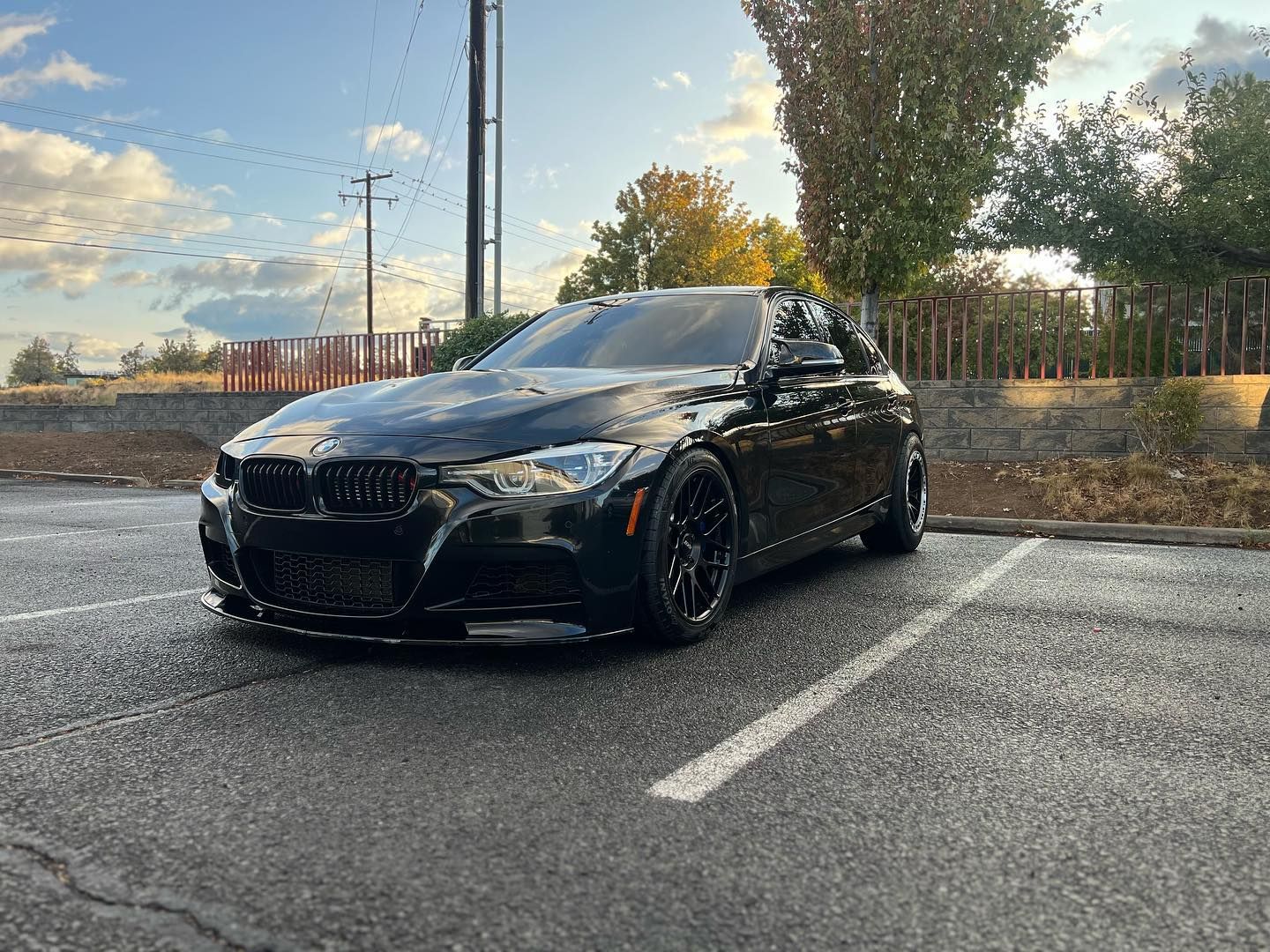 A black bmw m3 is parked in a parking lot.