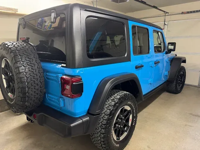 Blue car in a garage, showcasing auto window tint on the rear and side windows.