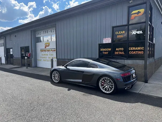 Gray Audi R8 outside same shop, showing PPF protection and shine. 